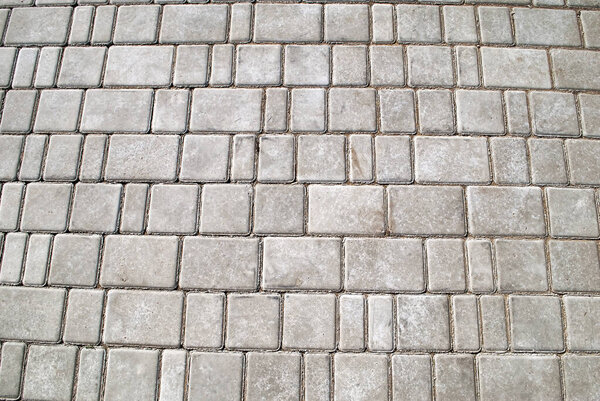 Gray paving stones. Gray sidewalk, rectangular and large and small. Tile texture.