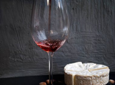 Kırmızı şarap, fındık ve peynir masada.