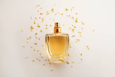 Çiçek kokulu bir parfüm. Sarı çiçeklerle çevrili parfüm şişesi.