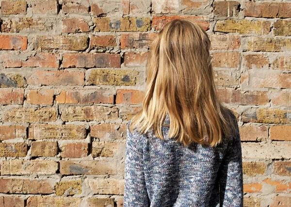 Visão Traseira Uma Menina Bonita Fundo Parede Tijolo Vermelho — Fotografia de Stock