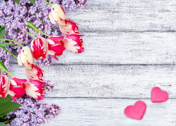 Lilac flowers with tulips with two hearts — Stock Photo, Image