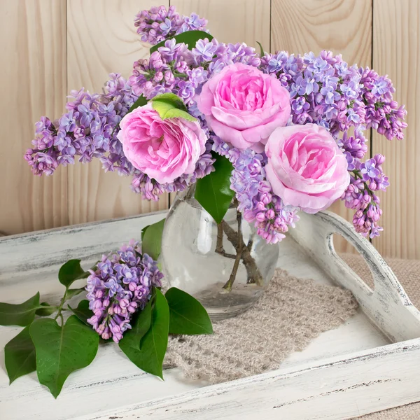 Fleurs et roses de lilas sur un salver en bois minable — Photo