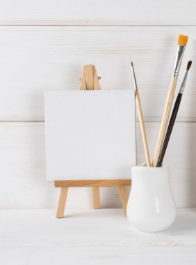 Miniature easel and paint brushes   clipart