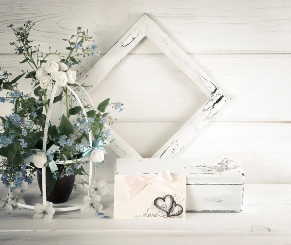 Forget-me-not bloemen met vogelkooi en foto frame met kist — Stockfoto