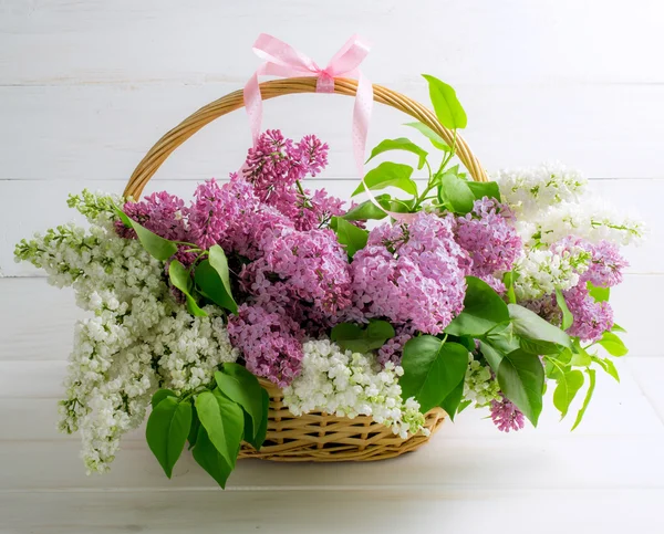 Buquê de lilás em cesta no fundo de tábuas de madeira gasto — Fotografia de Stock
