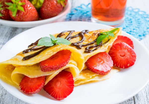 Pancakes with sliced strawberries and chocolate — Stock Photo, Image