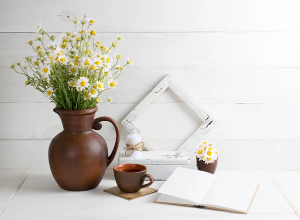 Gänseblümchen-Strauß mit Buch und Tasse Tee — Stockfoto