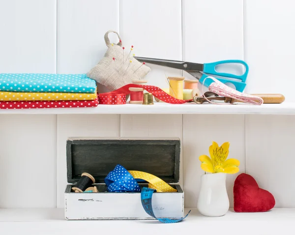 Set van instrumenten voor het naaien en het weefsel liggen op de houten plank. In — Stockfoto