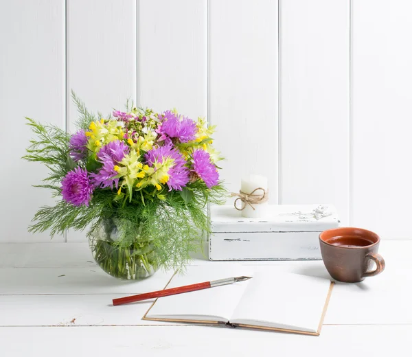Квіти букет у вазі з відкритим щоденником і фонтанною ручкою — стокове фото