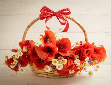 Haşhaş ve papatya buketi sepeti ahşap plakalar üzerinde 