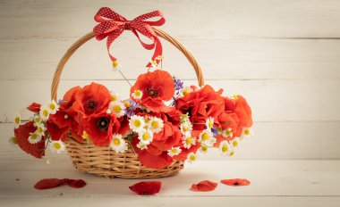 Haşhaş ve papatya buketi sepeti ahşap plakalar üzerinde 