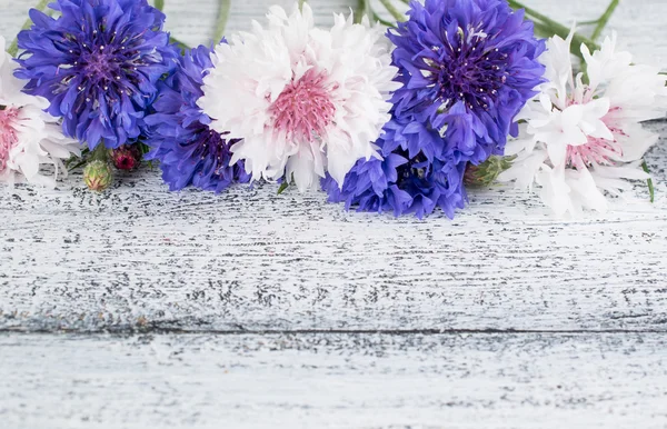 Korenbloemen liggend op houten planken — Stockfoto