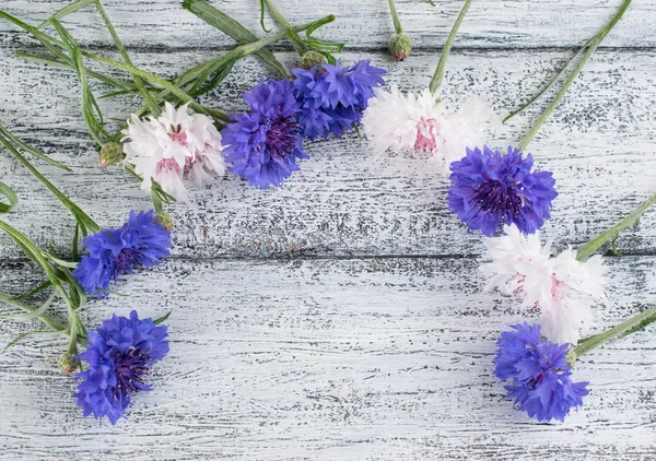 Korenbloemen liggend op houten planken — Stockfoto