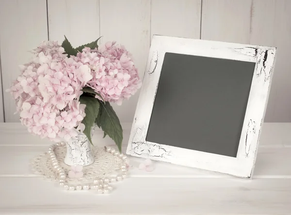 Hortense in retro vase with pearl necklace and photo frame in sh — Stock Photo, Image