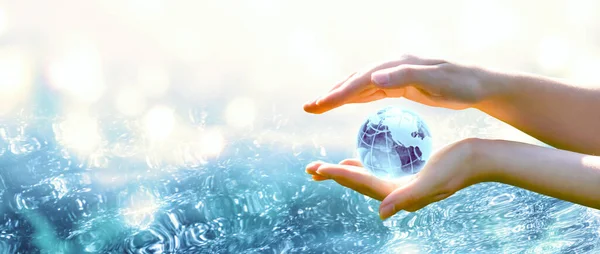 世界海洋日或水日卡片 蓝色的行星水晶玻璃球在人类手中 在纯净的大海背景上 拯救环境 保护清洁的地球和生态 可持续的生活方式概念 — 图库照片
