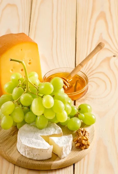 Bodegón de queso, miel, nueces y uvas — Foto de Stock