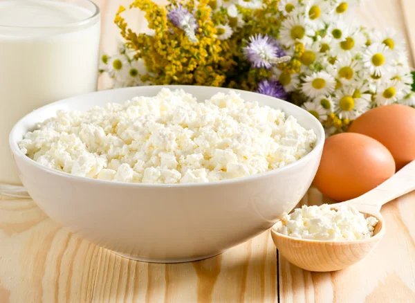 Cottage fromage avec lait et oeufs sur le pré fleurs backgrou — Photo