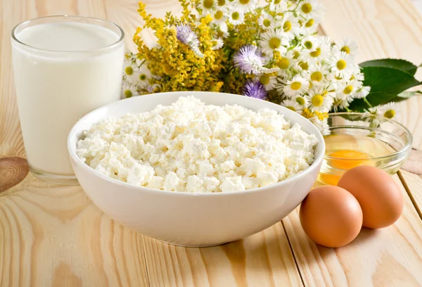 Queso casita con leche y huevos en el prado flores backgrou — Foto de Stock
