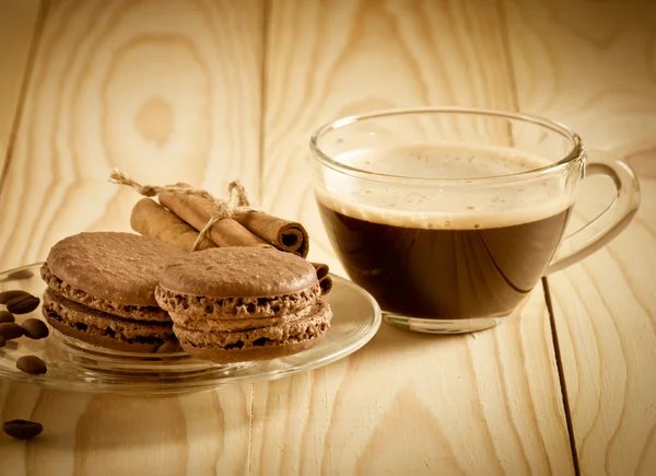 Koffiekopje met macaroon en kaneelstokjes — Stockfoto