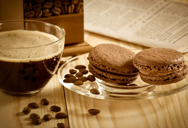Coffee cup with macaroon and newspaper — Stock Photo, Image