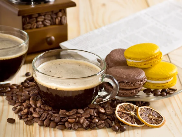 Coffee cup with macaroon and newspaper — Stock Photo, Image