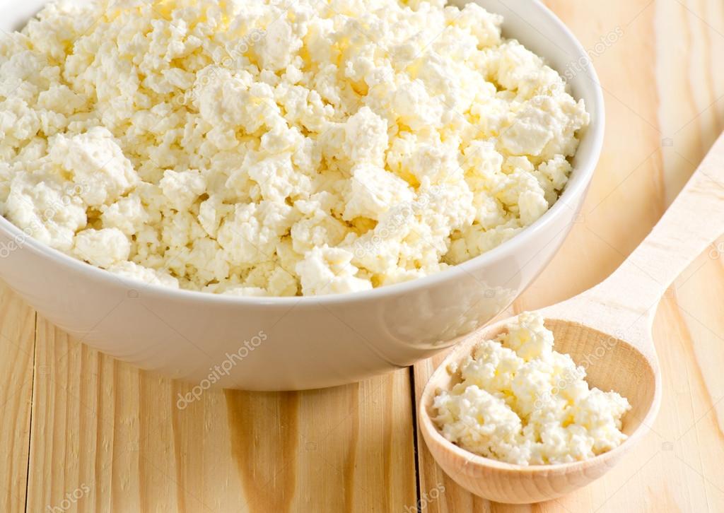  Cottage cheese in porcelain bowl with wooden spoon 