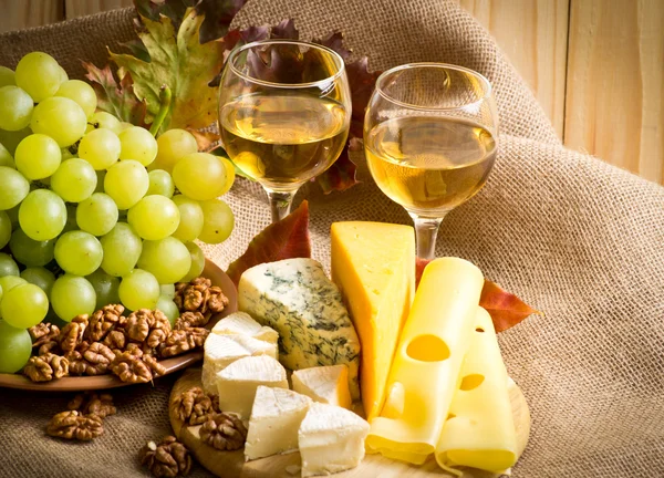 White wine with cheese, walnuts and grapes on sackcloth — Stock Photo, Image