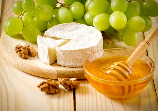 チーズ、蜂蜜、クルミおよびブドウの静物 — ストック写真