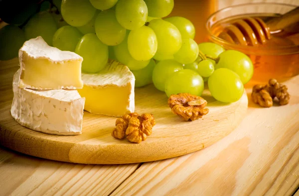 Bodegón de queso, miel, nueces y uvas — Foto de Stock