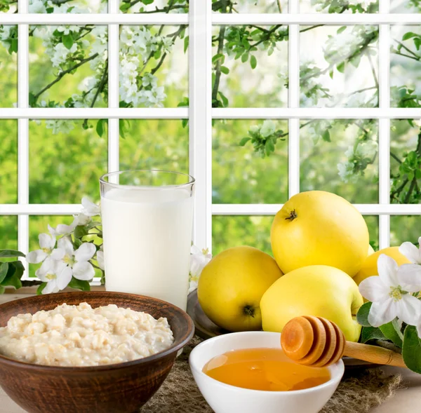 Stillleben mit Äpfeln, Haferflocken, Honig, Milch und Garten draußen — Stockfoto