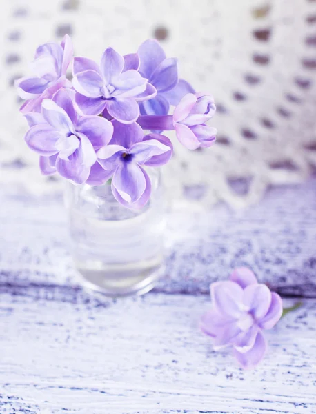 Lila bloemen in een kleine glazen fles — Stockfoto