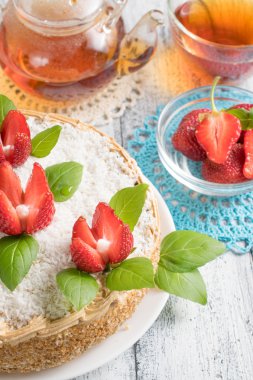 Celebratory cake with strawberries flowers and tea 