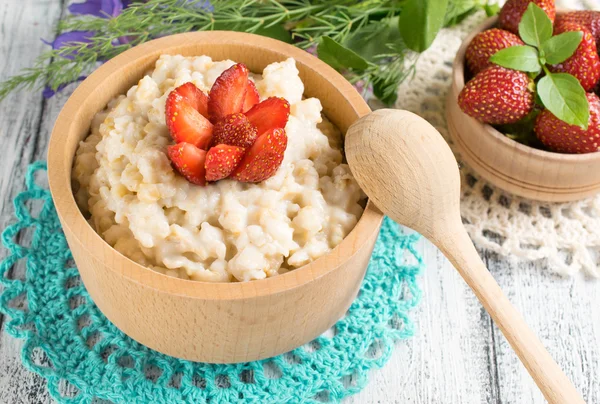 Farina d'avena con fragole nella ciotola di legno — Foto Stock