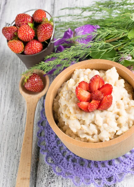 Harina de avena con fresas en el tazón de madera — Foto de Stock