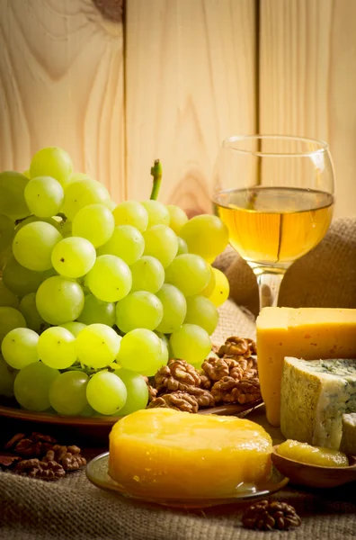 Белое вино с сыром, медом, грецкими орехами и виноградом на мешковине — стоковое фото