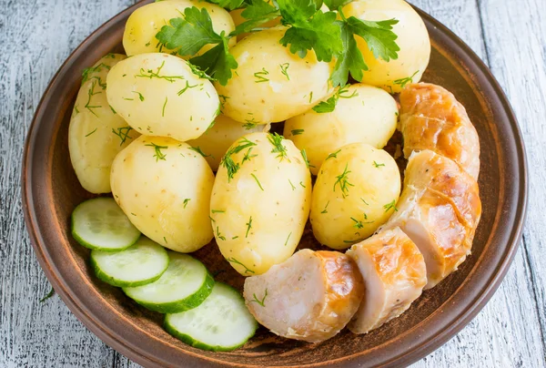 Young gekookte aardappelen met worst, komkommer, dille en peterselie — Stockfoto