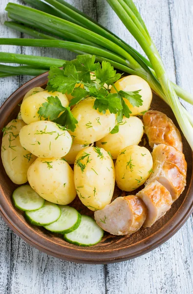Young gekookte aardappelen met worst, komkommer, dille en peterselie — Stockfoto