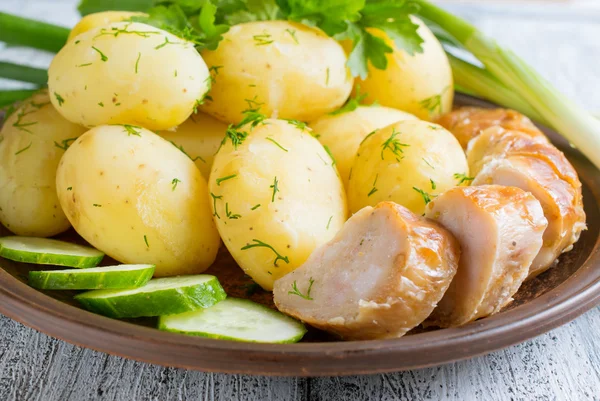 Young gekookte aardappelen met worst, komkommer, dille en peterselie — Stockfoto