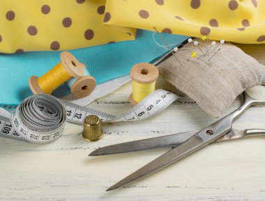 Makara iplik, santimetre, kumaş, yüksük ve makas, dikiş r