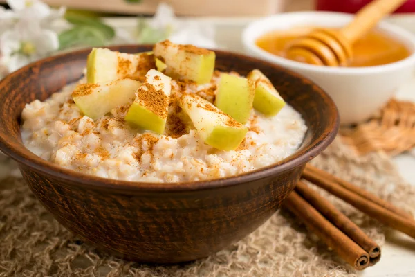 Harina de avena con manzana y canela en el bowl, miel y canela Fotos de stock libres de derechos