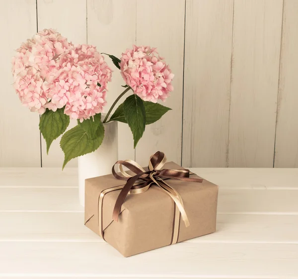 Hortense em vaso e caixa de presente em placa de madeira — Fotografia de Stock