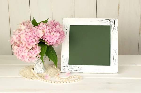 Hortense in retro vase and photo frame in shabby chic style.