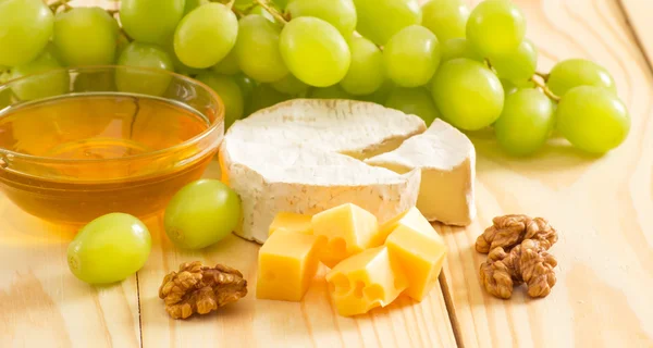 Nature morte de fromage, miel, noix et raisins — Photo