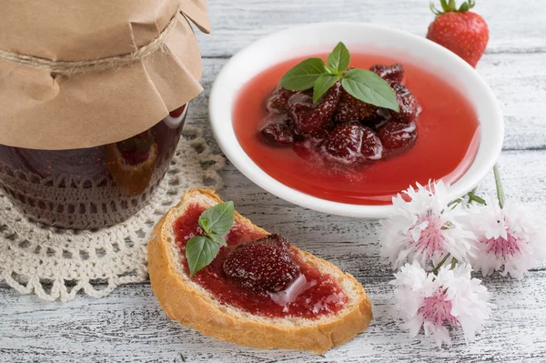 Erdbeerkonfitüre in Dosen und Marmeladensandwich auf dem Holzbrett — Stockfoto