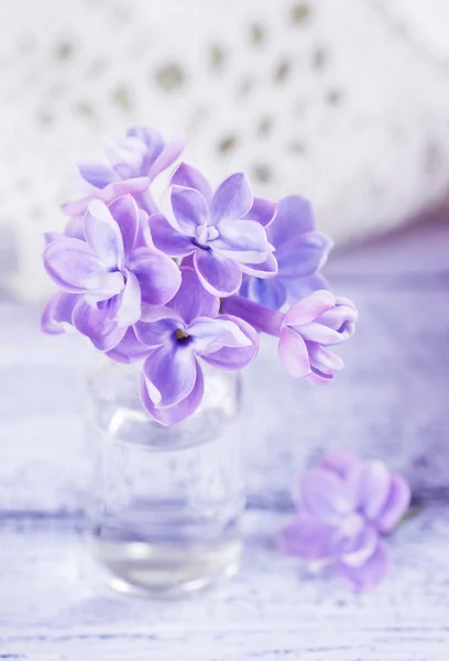 Lila bloemen in een kleine glazen fles — Stockfoto