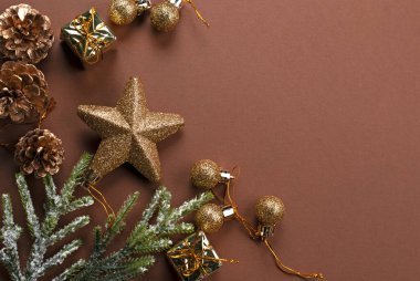 Noel arkaplanı dekoratif altın hediye kutuları, köknar dalı, parıldayan toplar, ağaç süslemesi için yıldız ve koniler. Yeni yıl kış tatili kompozisyonu dekor ve metin için kopyalama alanı, üst görünüm.