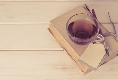 Dekoratif tebrik kartı, eski kitap ucu kalem ve fincan çay