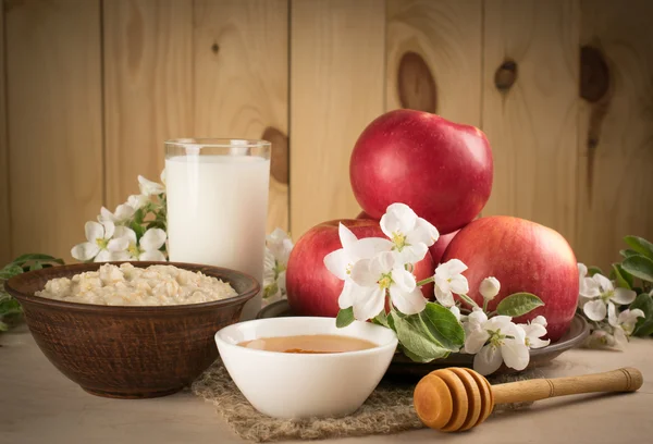 Röda äpplen med havregrynsgröt, mjölk och honung — Stockfoto