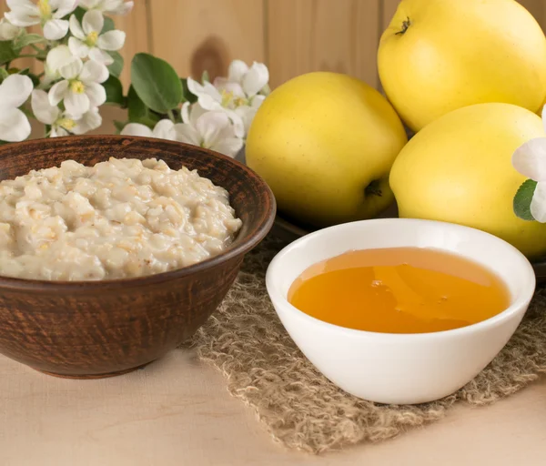 Yellow apples with oatmeal and honey, twig of apple tree — Stock Photo, Image