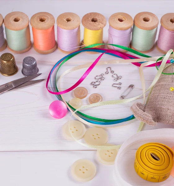 Conjunto para costura, tricô e bordado em uma tábua de madeira — Fotografia de Stock